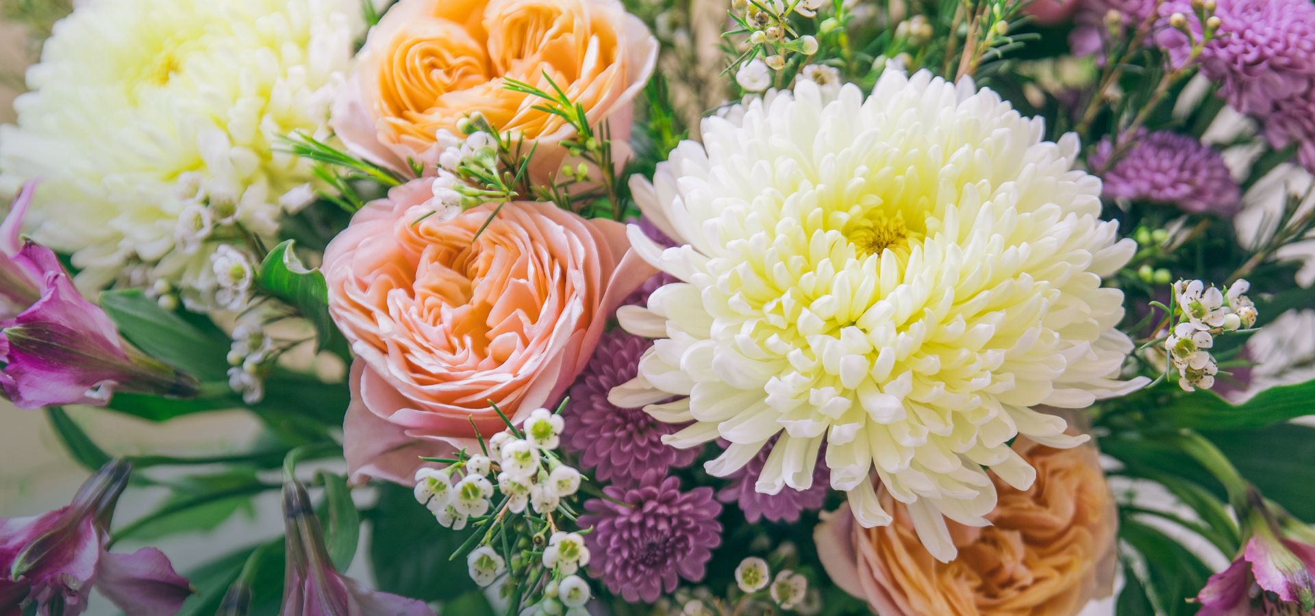 Detalle de cerca de flores frescas: con crisantemos blancos y rosas melocotón de la nueva Colección de Verano de Colvin.