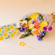 Ramo de flores coloridas con envoltorio, vela y tarjeta