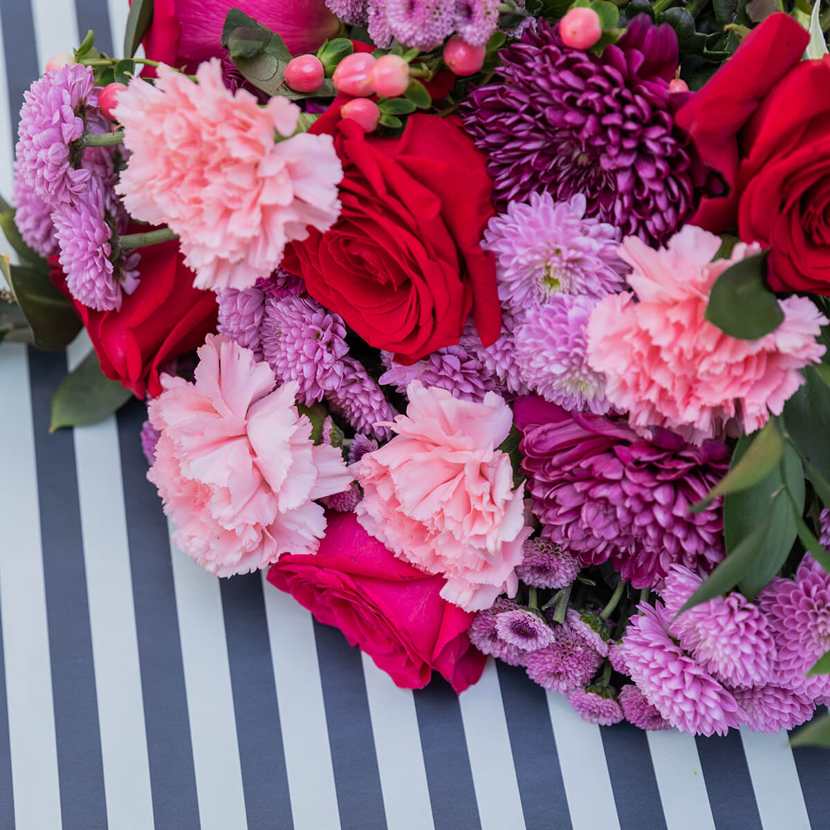 El Hechizo - Ramo de flores rojas y moradas