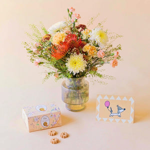 Ramo de flores naranjas con jarrón, galletas y tarjeta