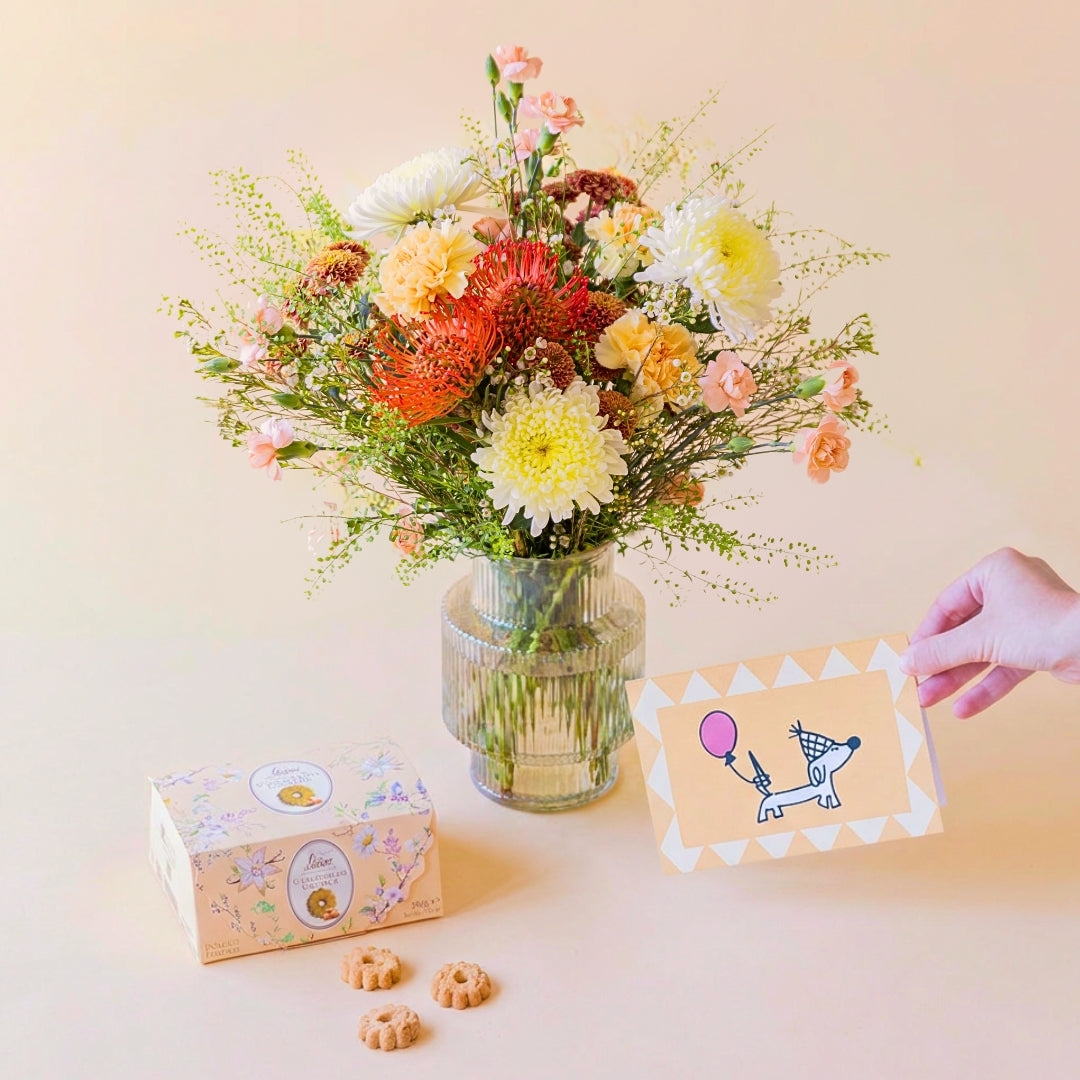 Ramo de flores naranjas con jarrón, galletas y tarjeta