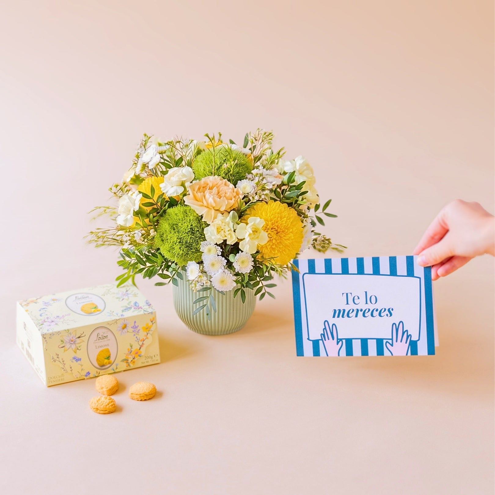 Arranjo de flores amarelas, biscoitos e cartão