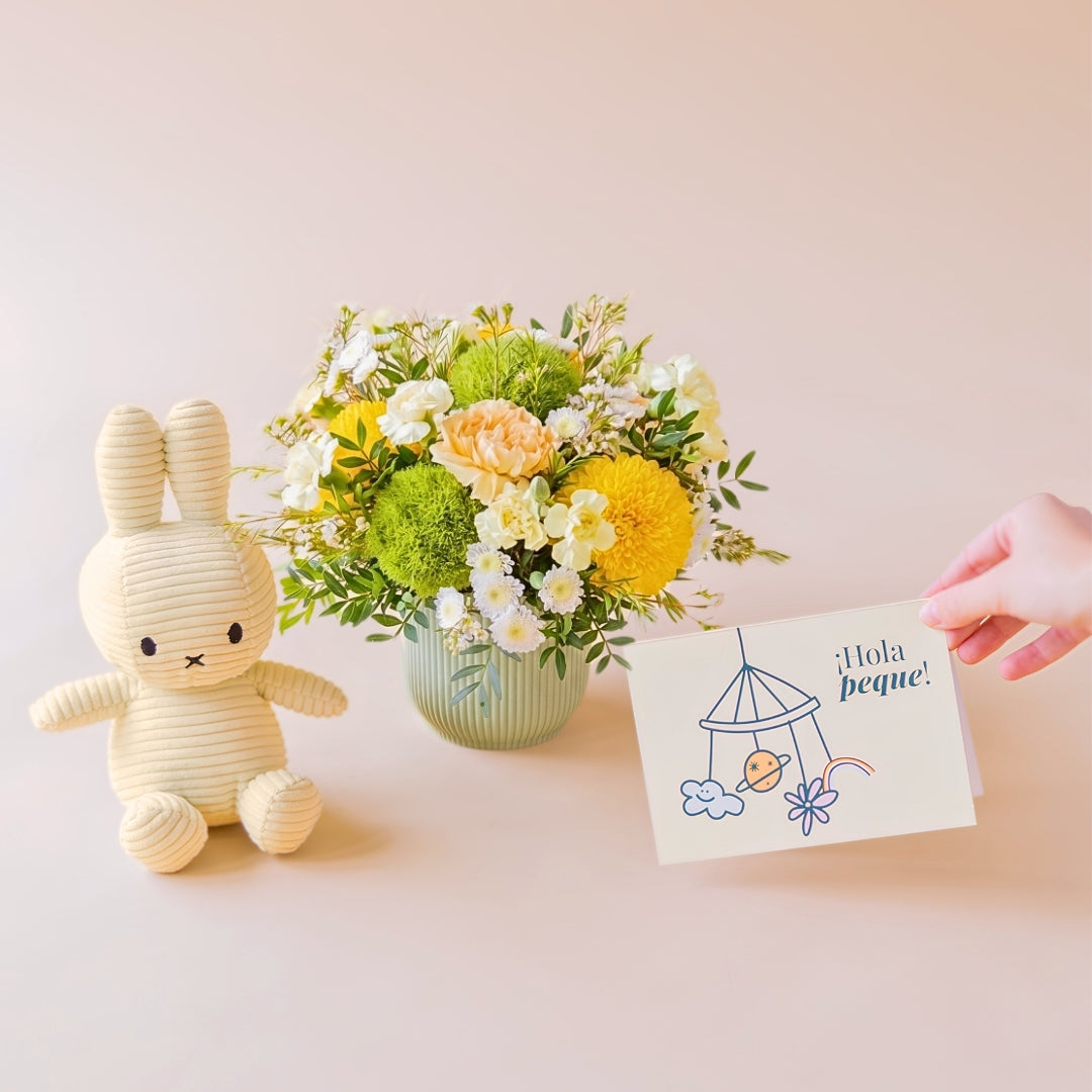Pack de arreglo de flores amarillas, cremas y verde con peluche Miffy color amarillo y mano sosteniendo una tarjeta "¡Hola Peque!"