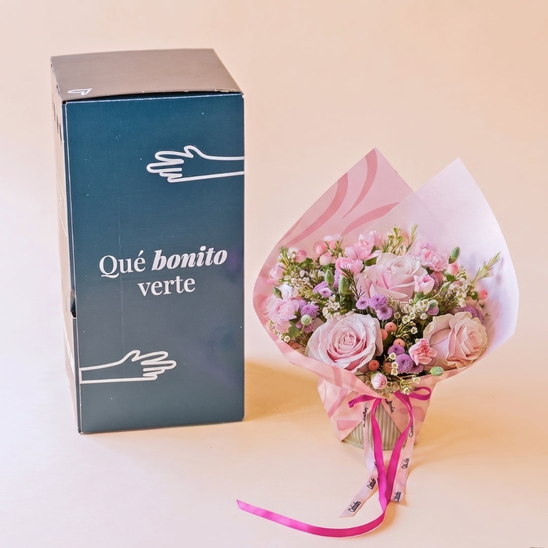 Arreglo de rosas rosas con envoltorio y tarjeta