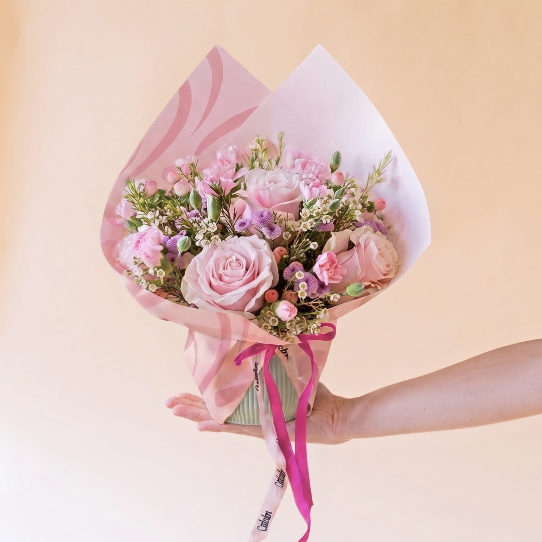 Arreglo de rosas rosas con envoltorio y tarjeta