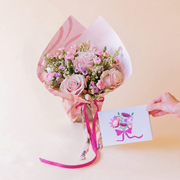 Arreglo de rosas rosas con envoltorio y tarjeta