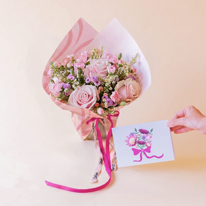Arreglo de rosas rosas con envoltorio y tarjeta
