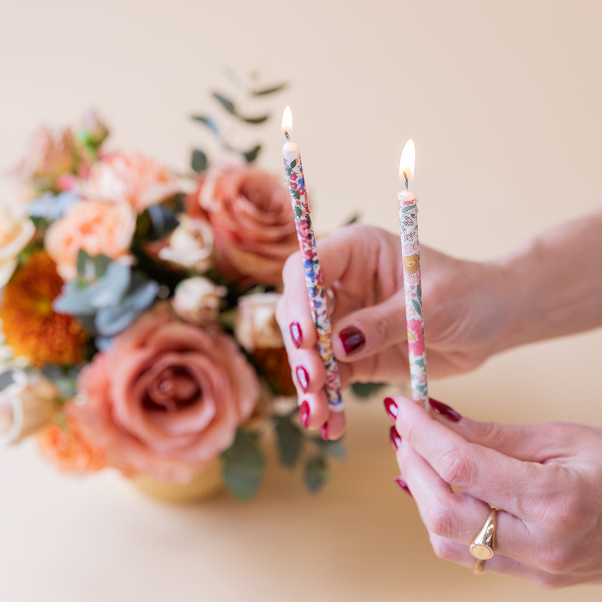 Arranjo floral Liberty com velas e cartão.