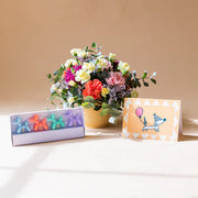 Arranjo de flores com velas e cartão