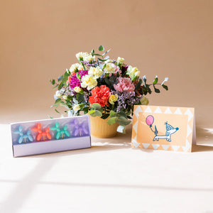 Arranjo de flores com velas e cartão