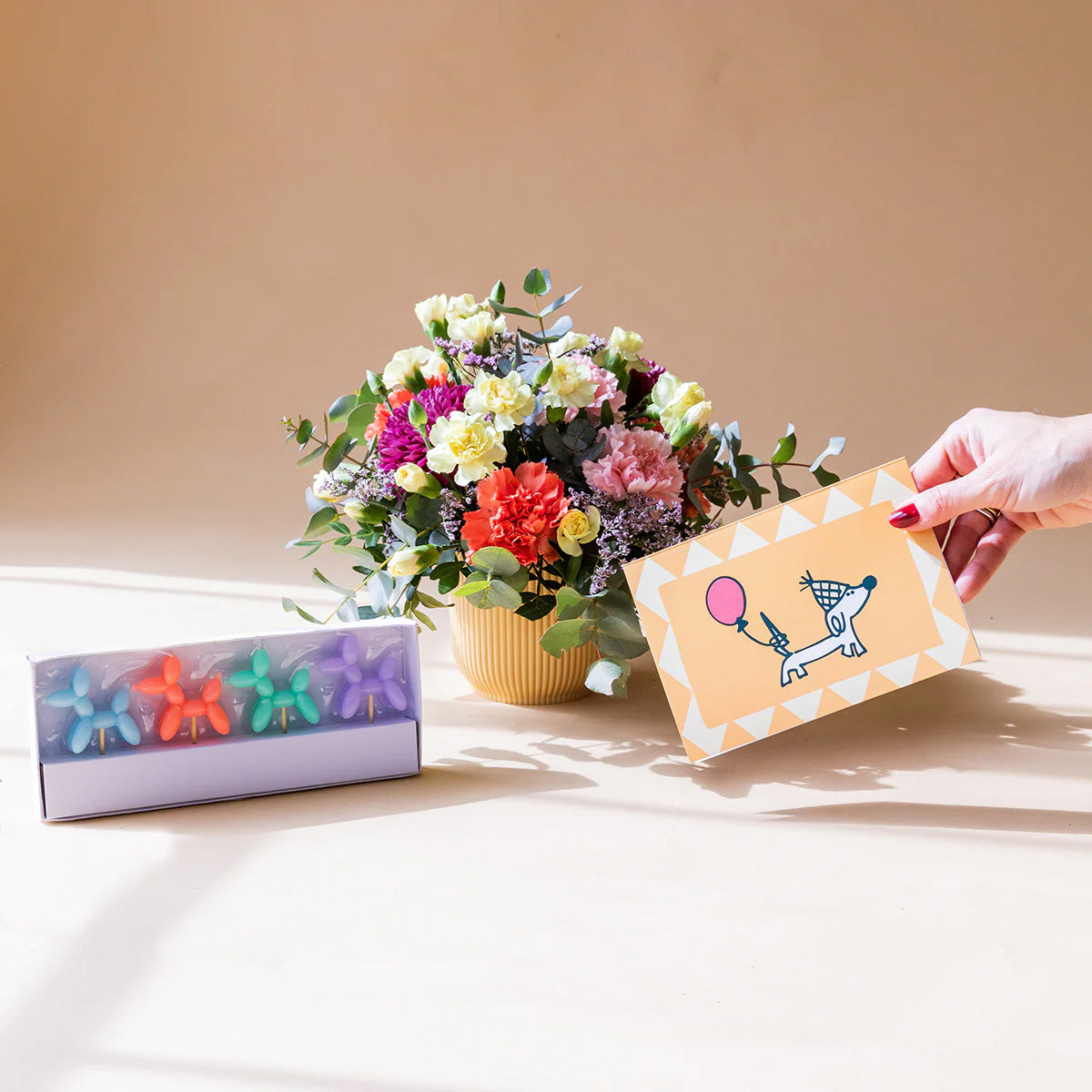 Arranjo de flores com velas e cartão