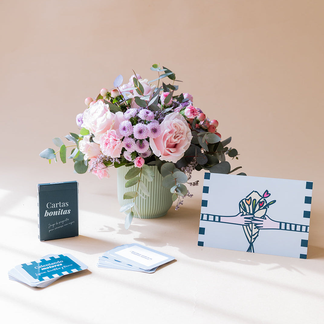 Arranjo de rosas com cartas de jogar e cartão