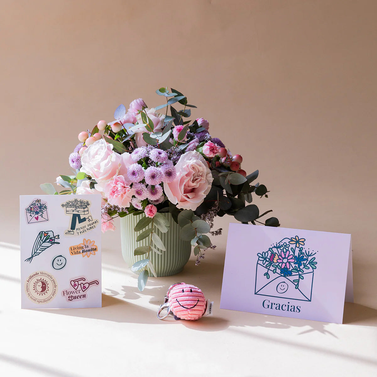 Arranjo de flores com porta-chaves, autocolantes e cartão.