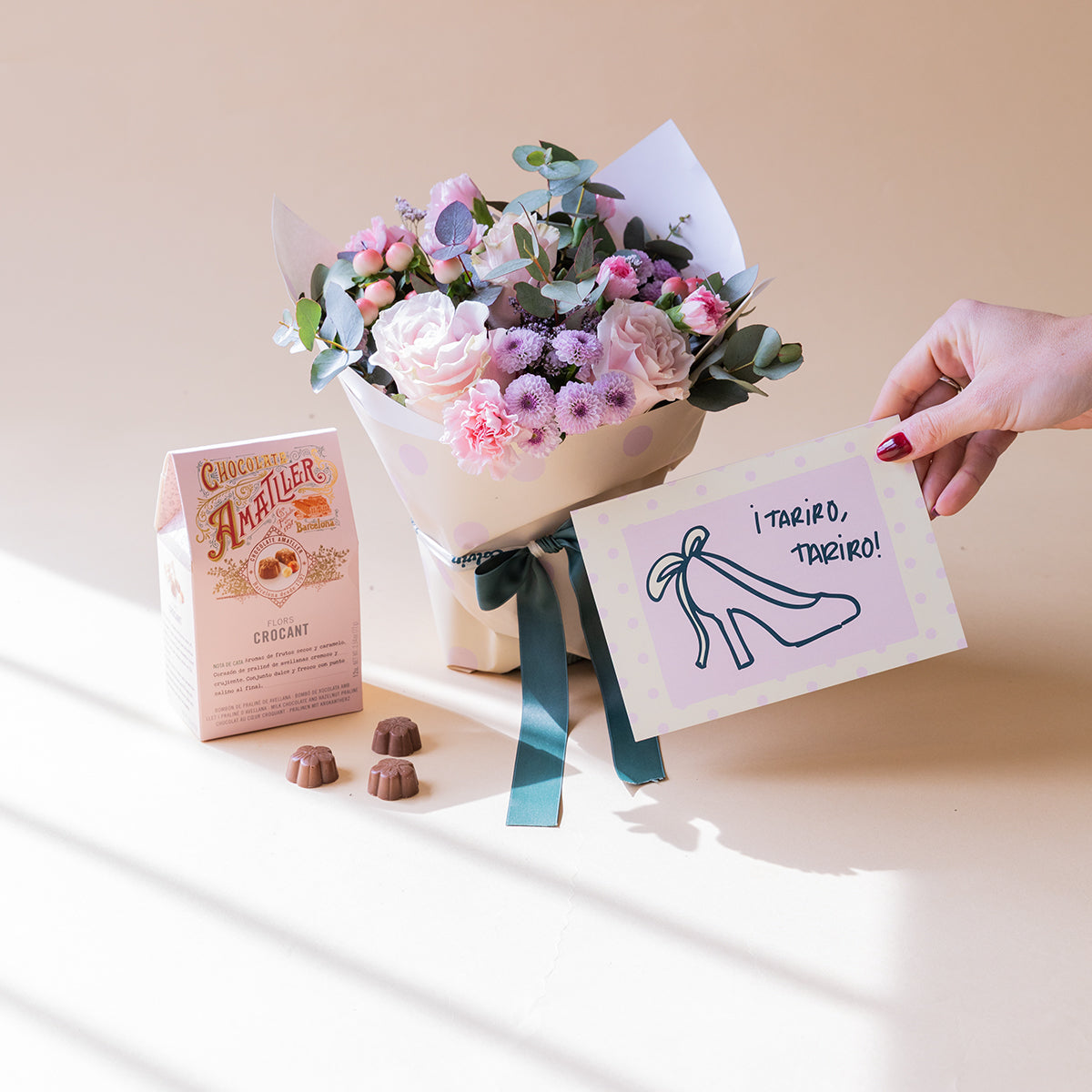 Arranjo de rosas com embalagem, chocolates e cartão.