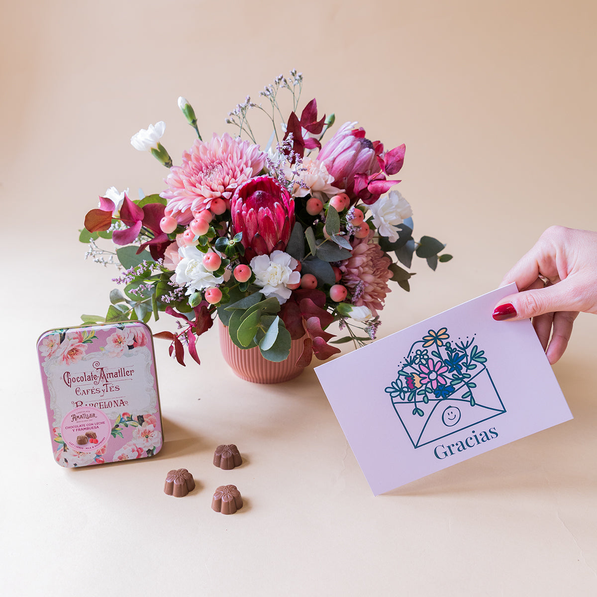 Arranjo de protea com chocolates e cartão.