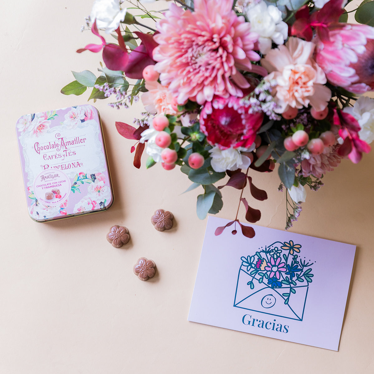 Arranjo de protea com chocolates e cartão.