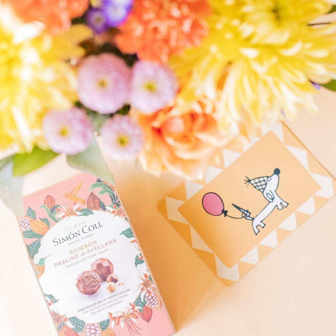 Ramo de flores coloridas con bombones y tarjeta