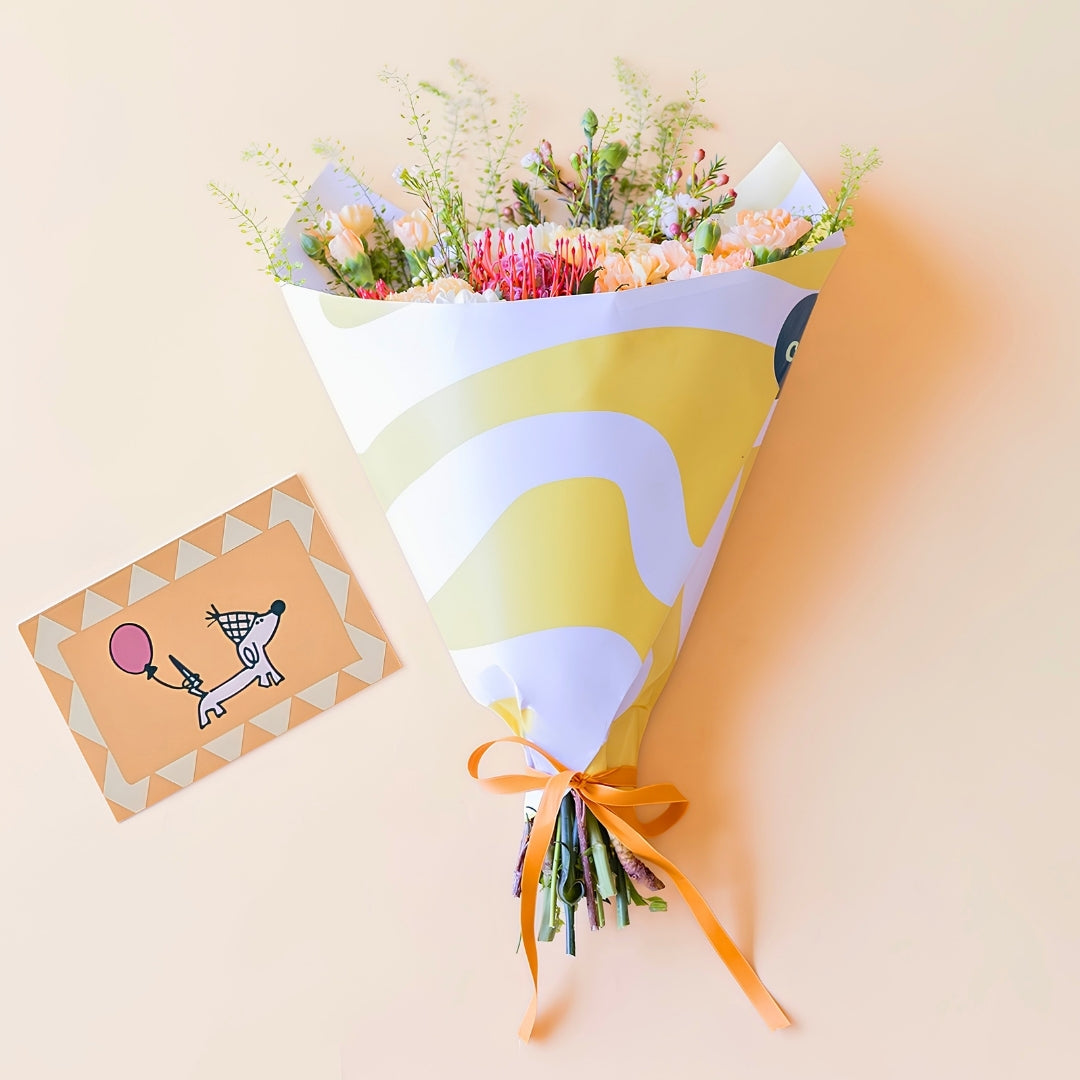 Ramo de flores naranjas con envoltorio y tarjeta