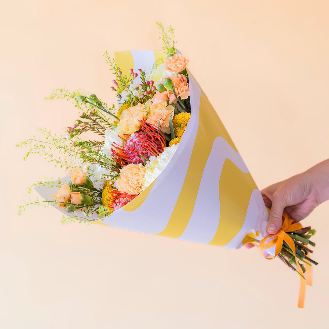 Ramo de flores naranjas con envoltorio y tarjeta