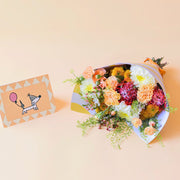 Ramo de flores naranjas con envoltorio y tarjeta