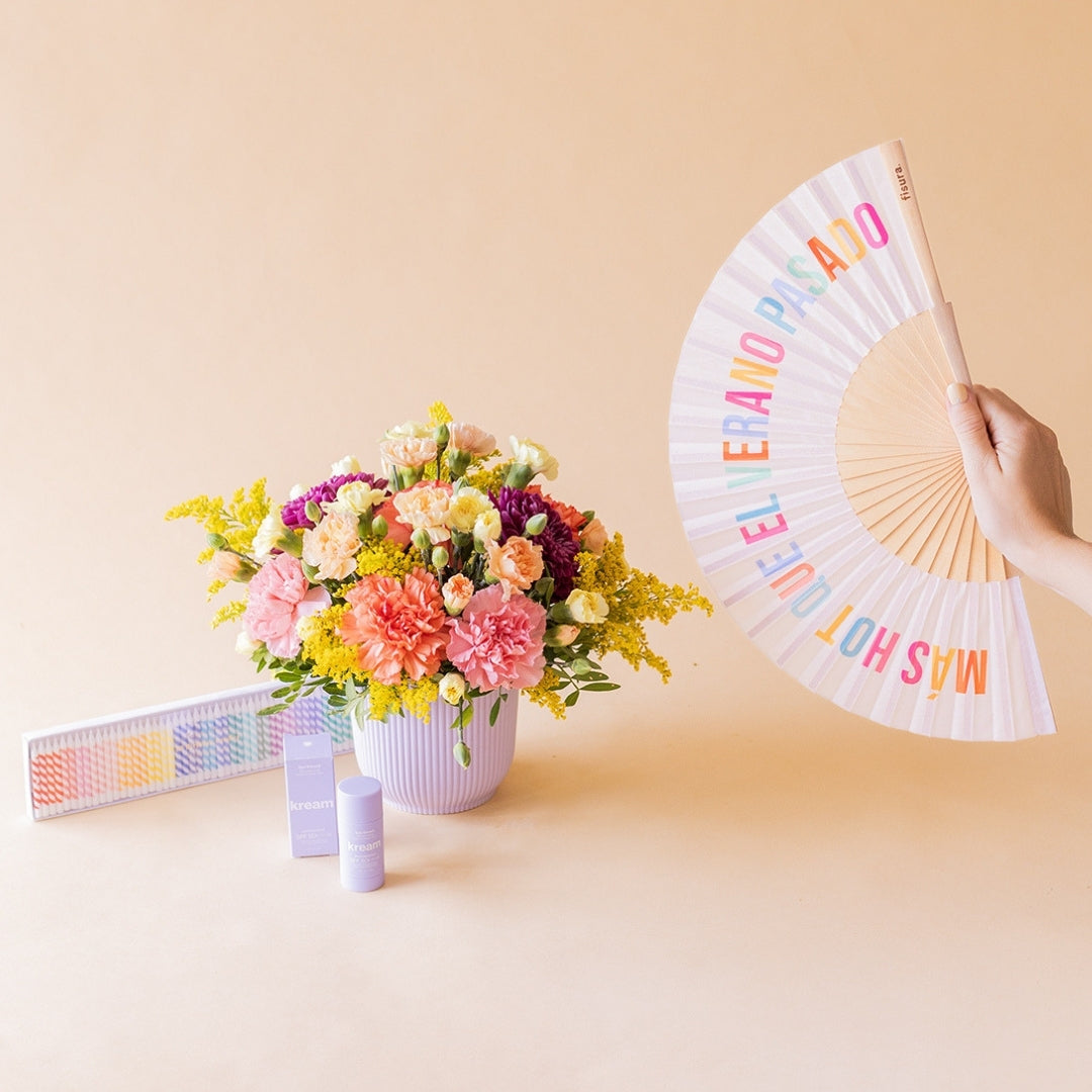 Arreglo de flores con abanico Fisura, velas arcoíris y protector solar Kream