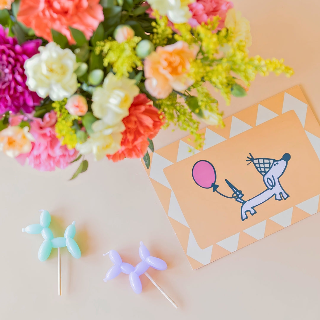 Arreglo de flores con velas y tarjeta