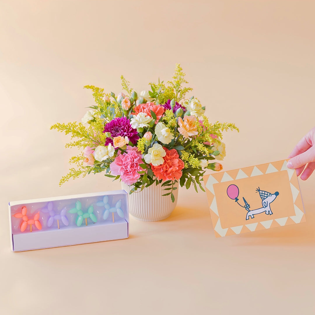 Arreglo de flores con velas y tarjeta