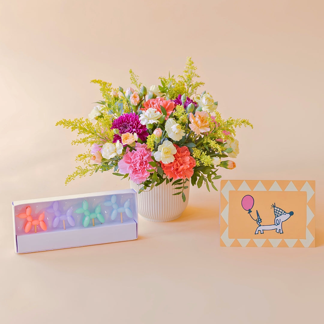 Arreglo de flores con velas y tarjeta
