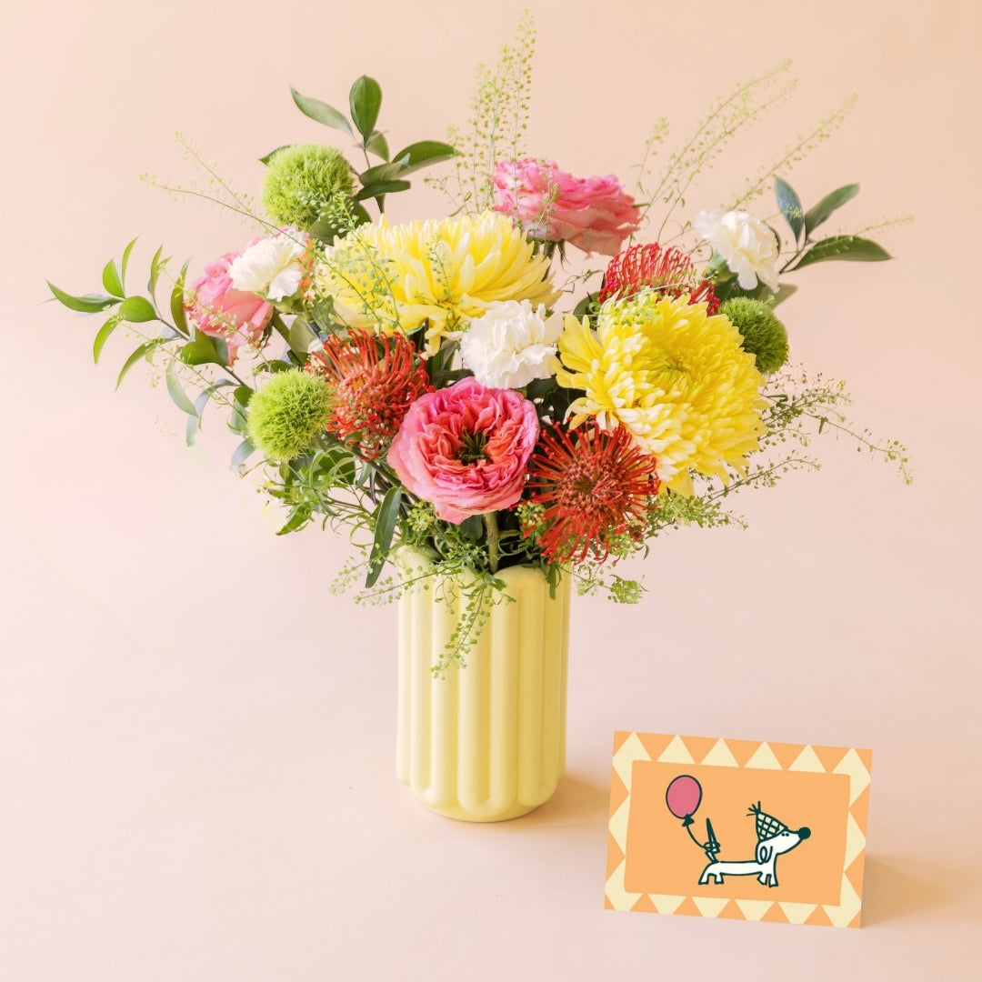 Ramo Verbena con flores de verano, rosas de jardín y nutans, con jarrón de cerámica amarillo y tarjeta de cumpleaños con perrito y globo. 