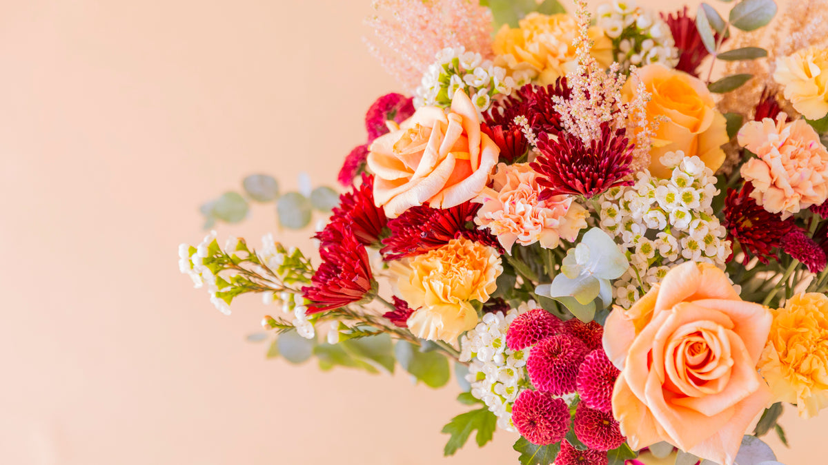 Ramo de flores de otoño con rosas salmón, claveles y crisantemos burdeos