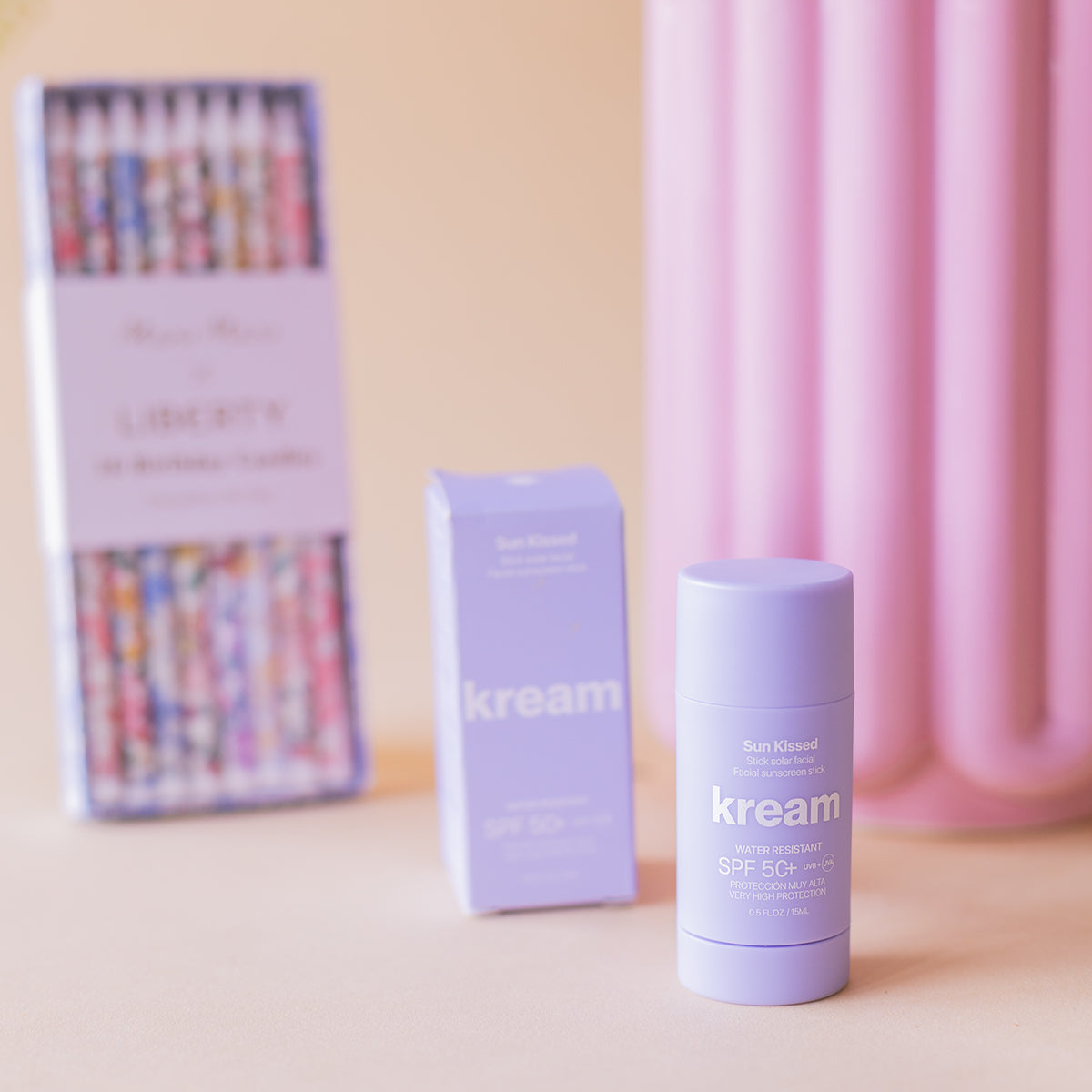 Bálsamo solar Kream SPF 50+ y velas Liberty de cumpleaños junto a jarrón rosa, pack de verano Colvin