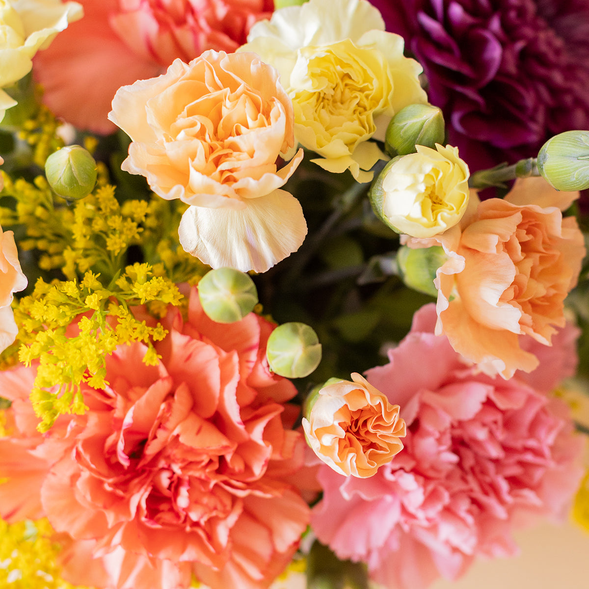Arreglo de flores con abanico Fisura, velas arcoíris y protector solar Kream