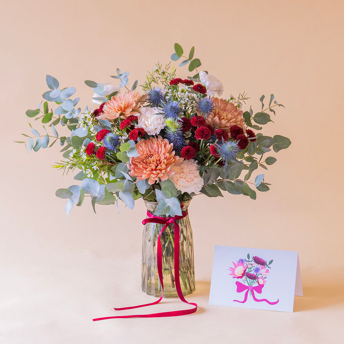 Ramo de flores azules con jarrón y tarjeta