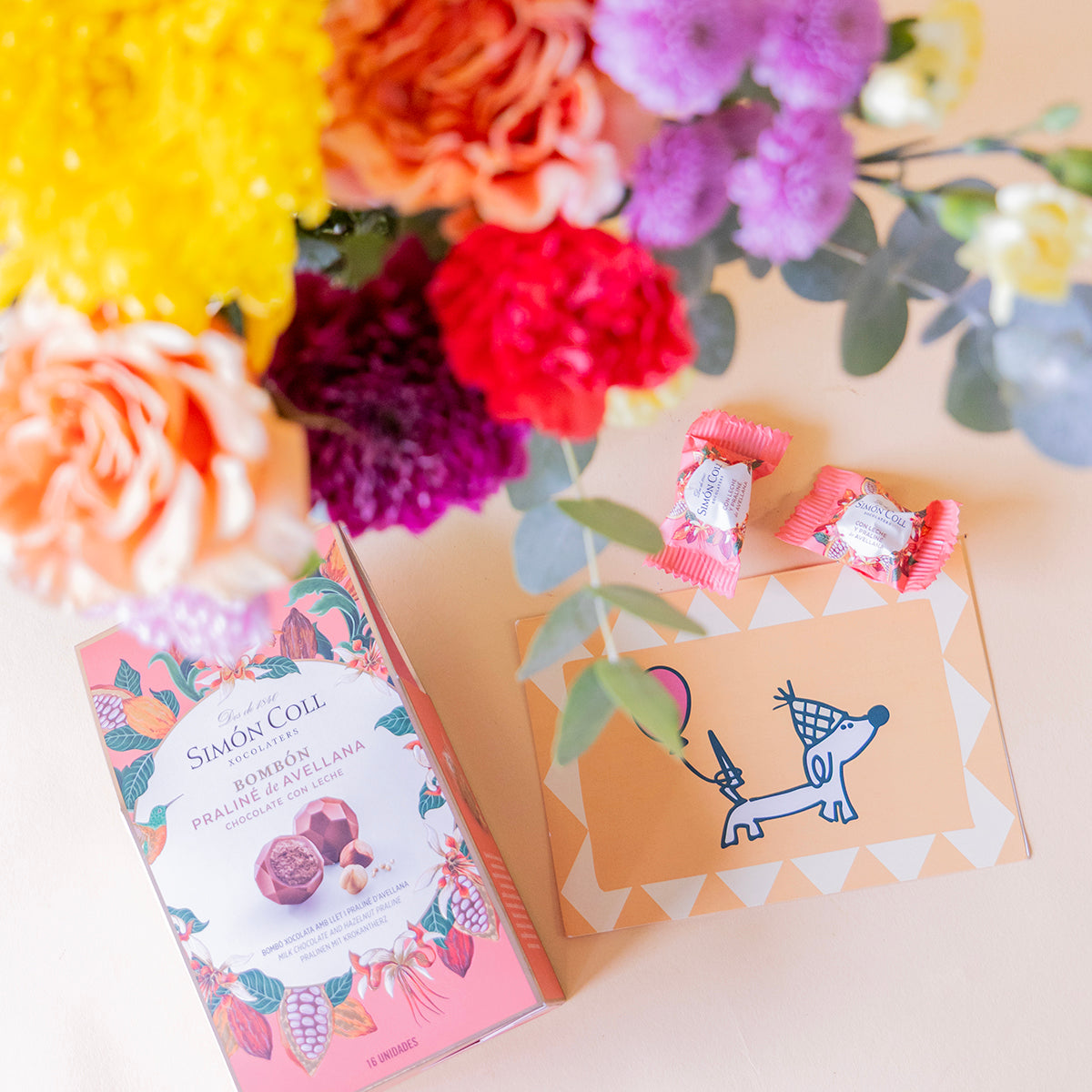 Ramo de flores coloridas con bombones y tarjeta