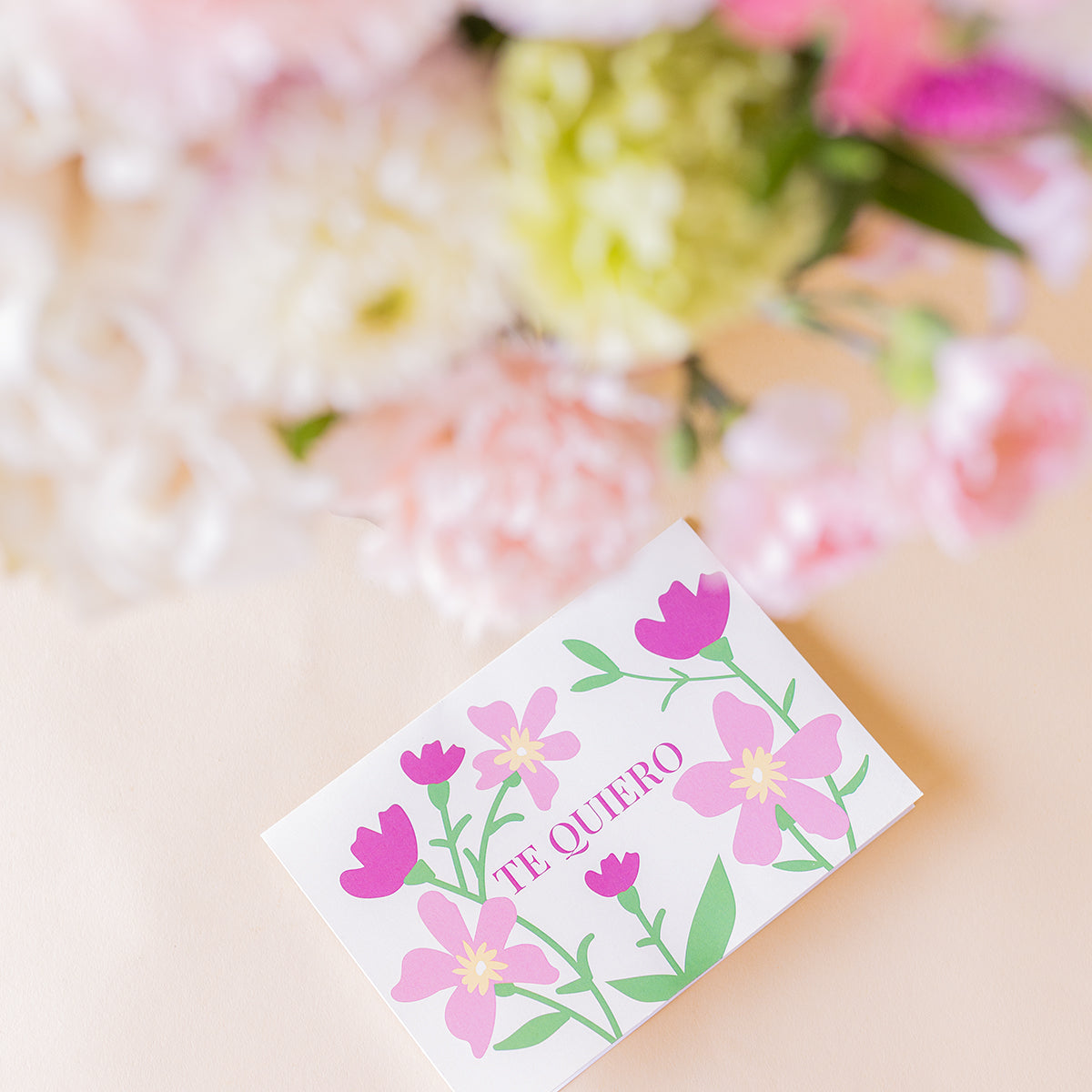 Tarjeta Te quiero de Colvin con ilustración floral rosa sobre fondo crema