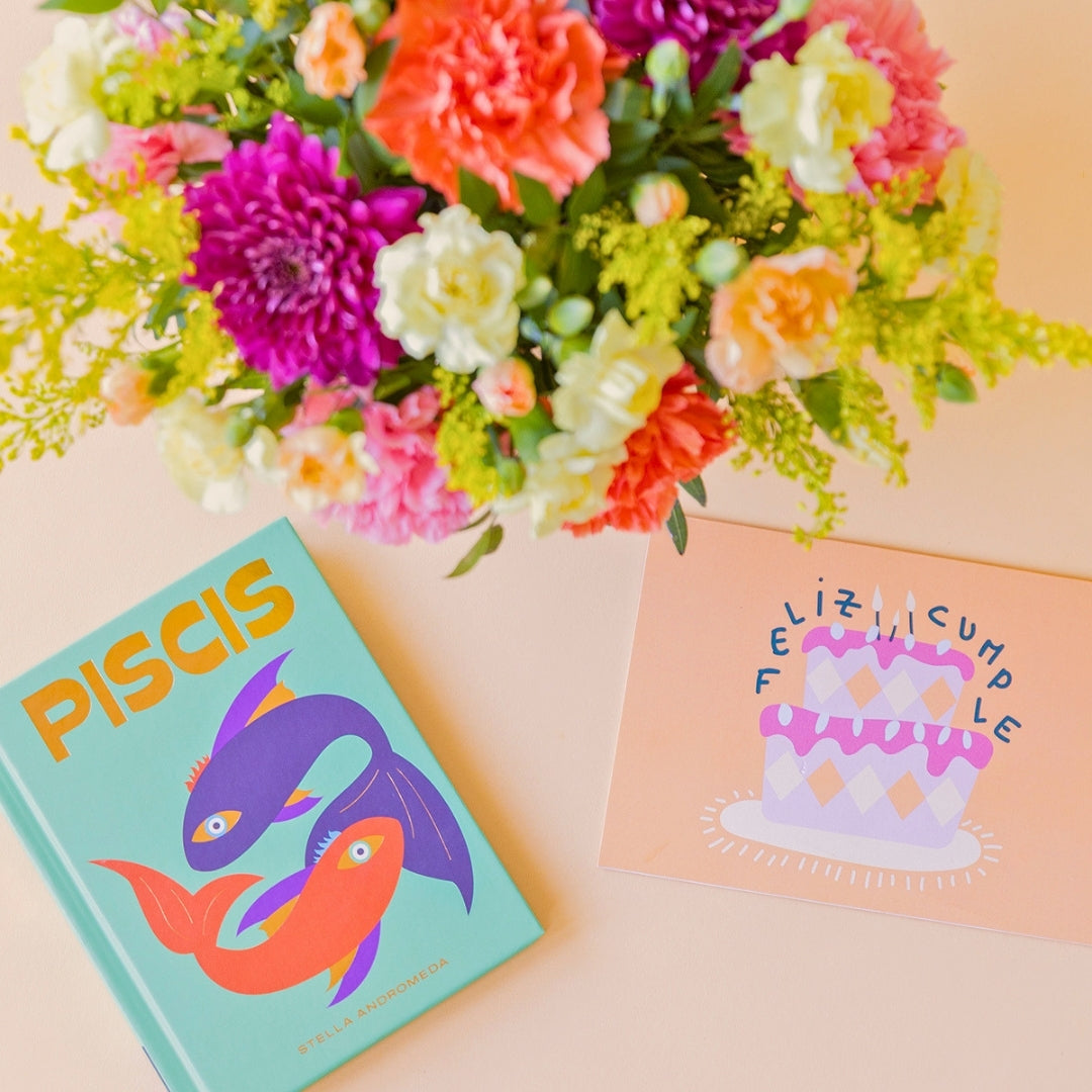 Arreglo de flores con libro horóscopo y tarjeta
