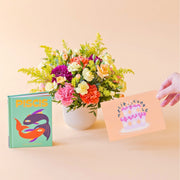 Arreglo de flores con libro horóscopo y tarjeta