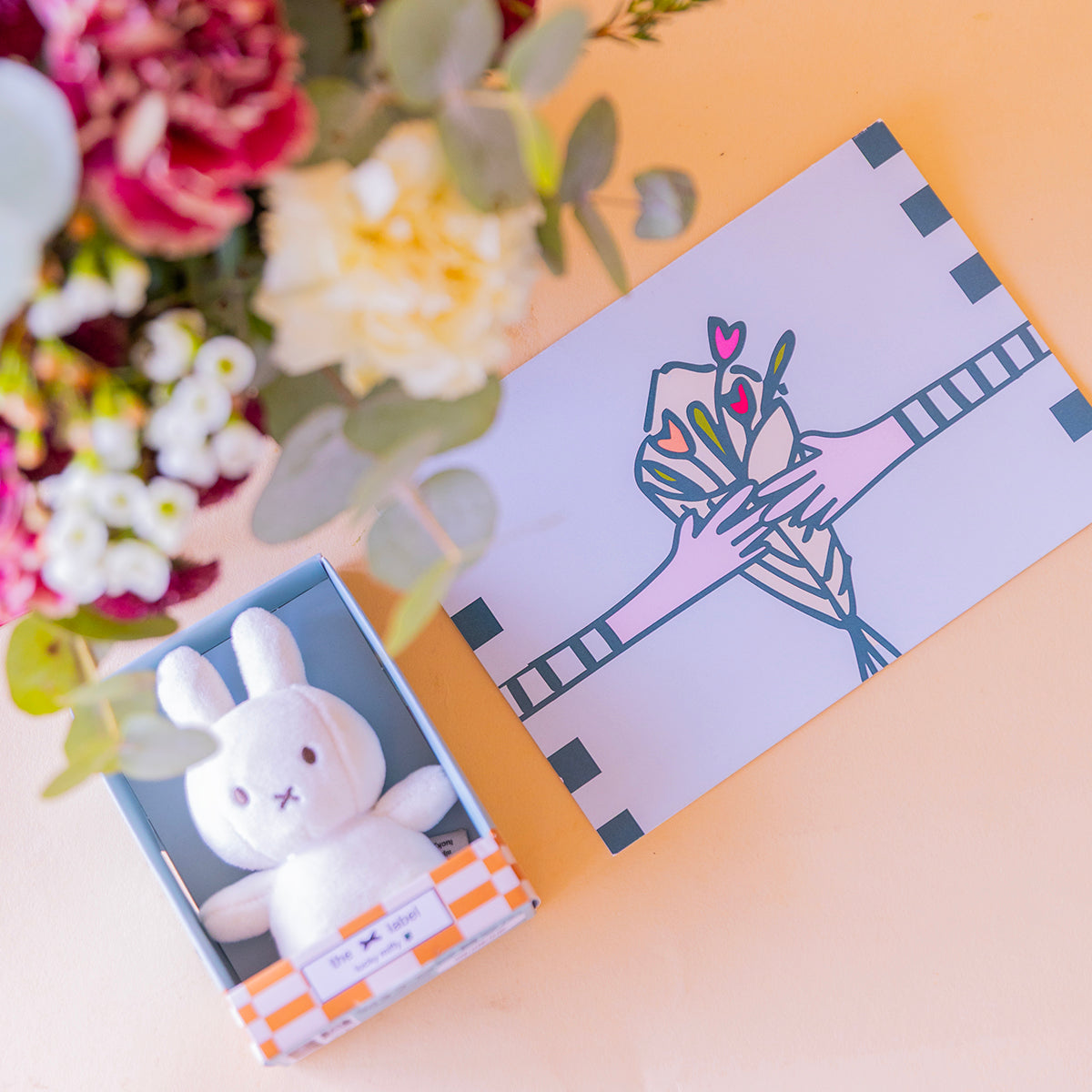 Detalle de mini peluche Miffy y tarjeta ilustrada del arreglo de claveles — Colvin