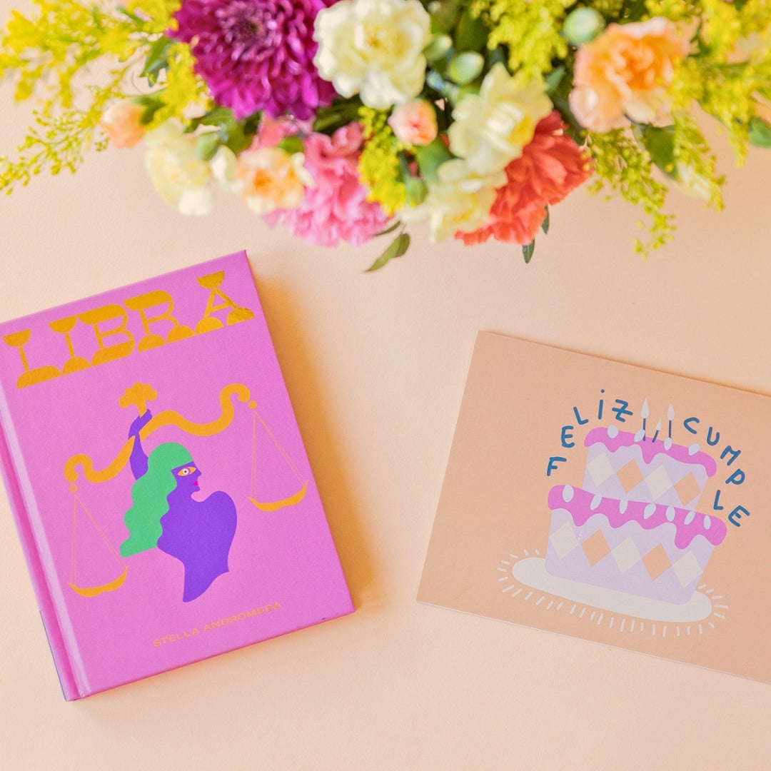 La Chispa - Libro horóscopo Libra y tarjeta Feliz Cumpleaños junto a arreglo floral de colores de Colvin.