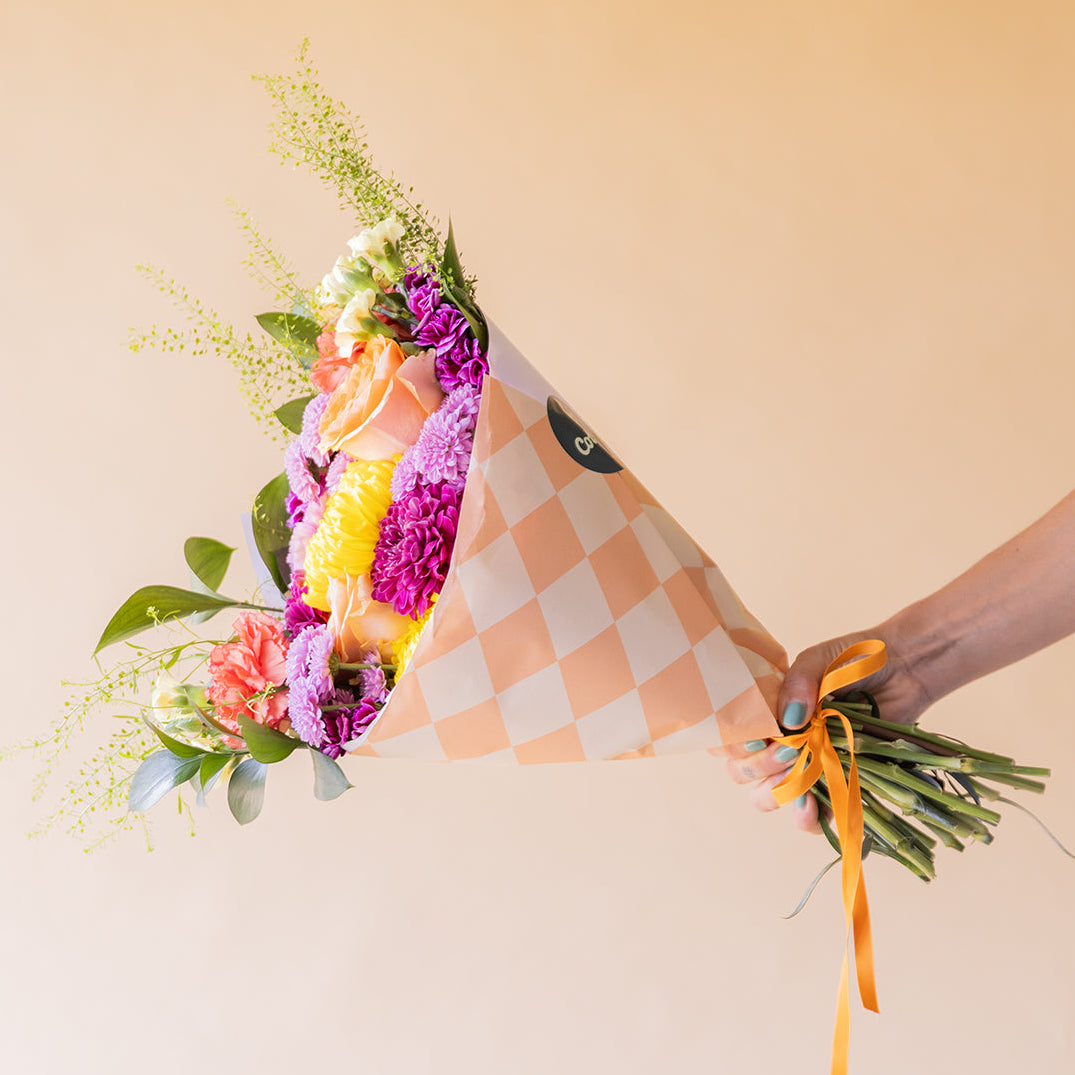 Ramo de flores de cumpleaños con rosas, crisantemos y claveles en papel a cuadros de Colvin