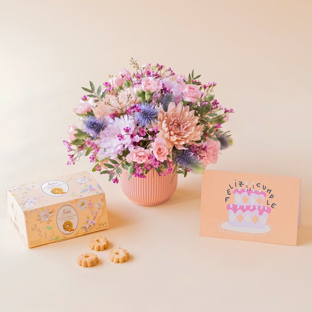 Regalo de cumpleaños Colvin con arreglo floral de crisantemos malva, claveles rosas, cardos azules, galletas de caramelo Loison y tarjeta.