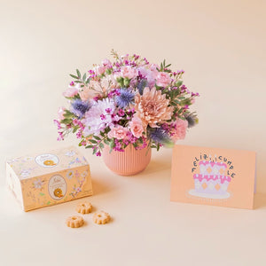 Regalo de cumpleaños Colvin con arreglo floral de crisantemos malva, claveles rosas, cardos azules, galletas de caramelo Loison y tarjeta.