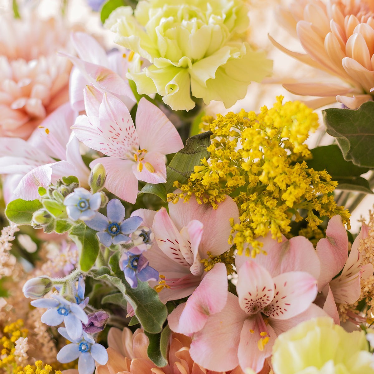 Ramo El Silvestre de Colvin con crisantemos melocotón, alstroemerias rosas, flores silvestres amarillas y lilas