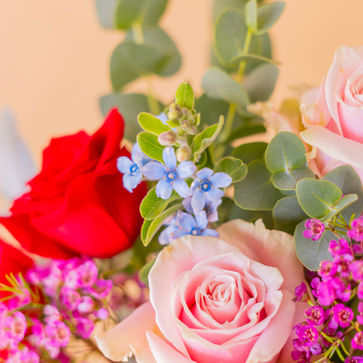 Ramo encanto con rosas de colores  y flores silvestres sobre fondo crema