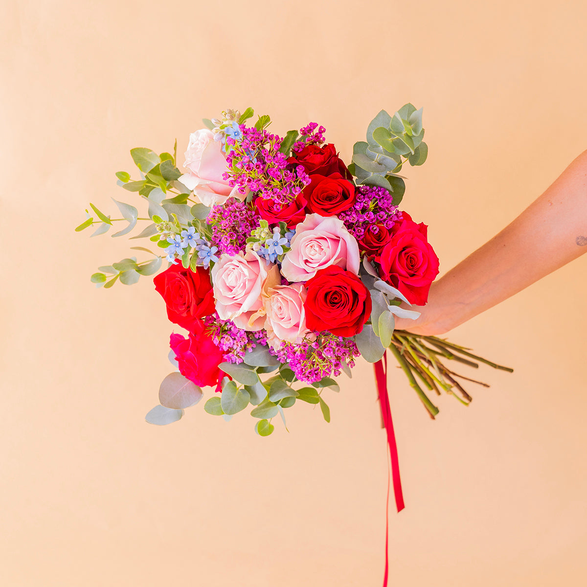 Ramo encanto con rosas de colores  y flores silvestres sobre fondo crema