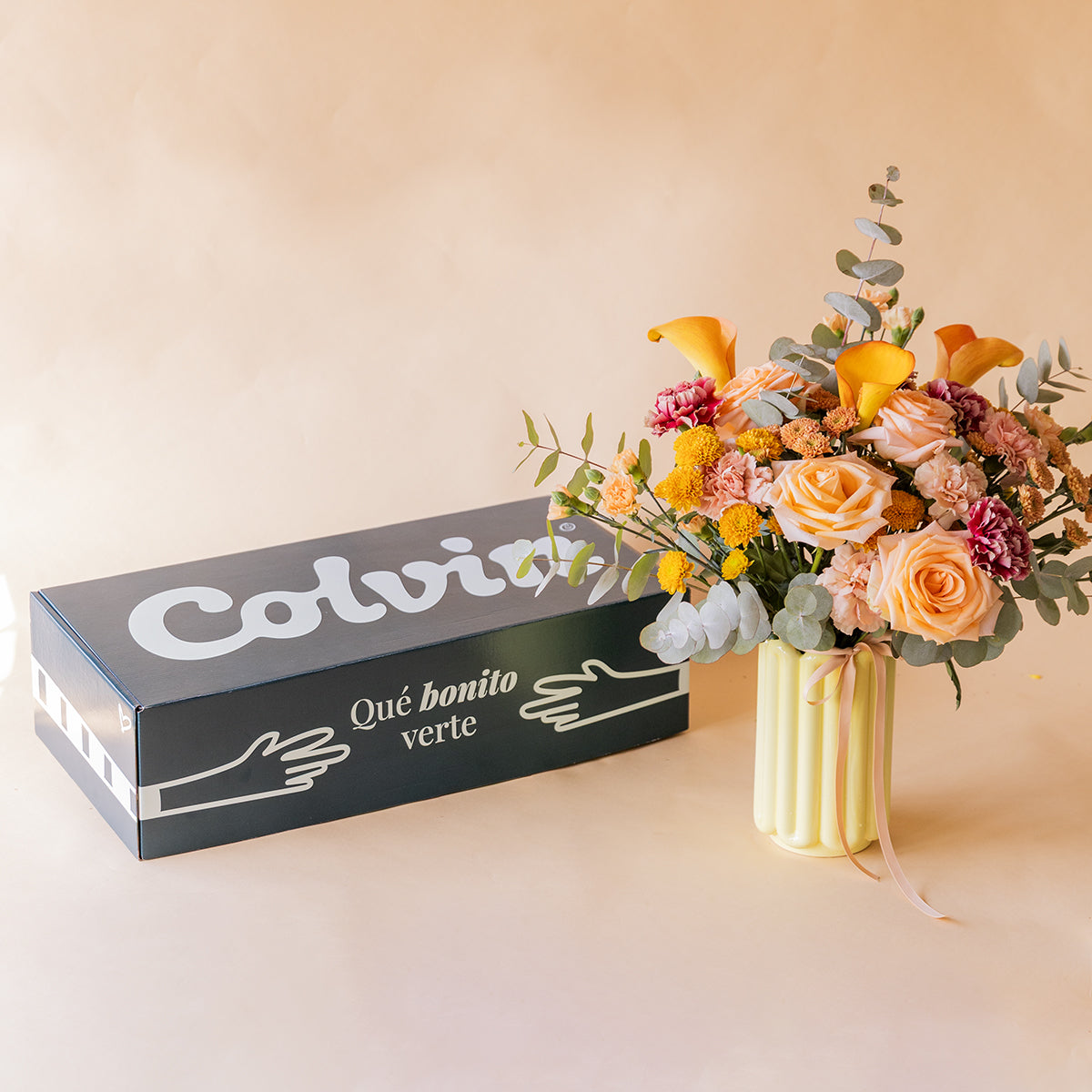 	Ramo El Ginger en jarrón amarillo junto a caja de envío Colvin — flores naranjas a domicilio
