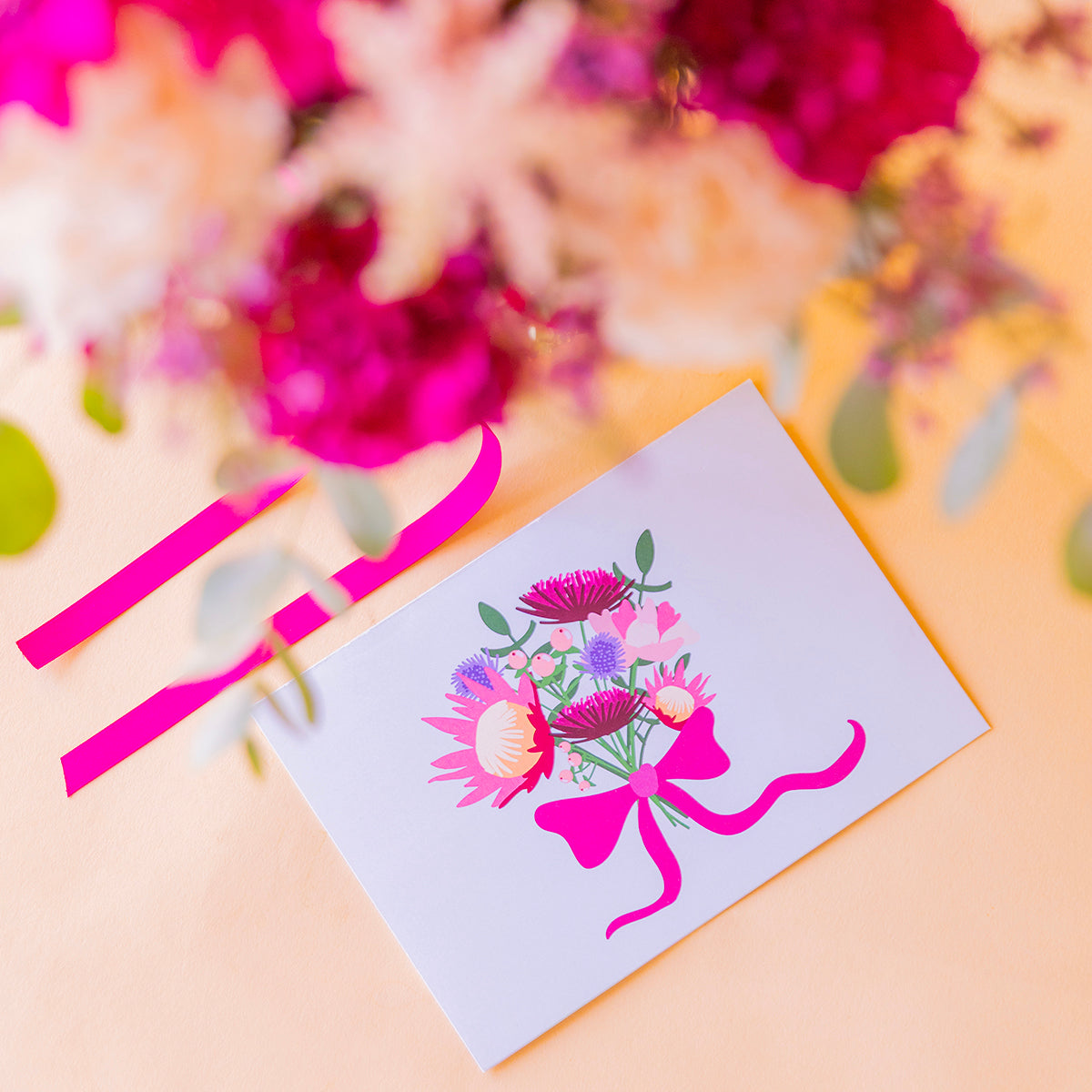 detalle cenital de la tarjeta floral Proteas con el ramo desenfocado al fondo