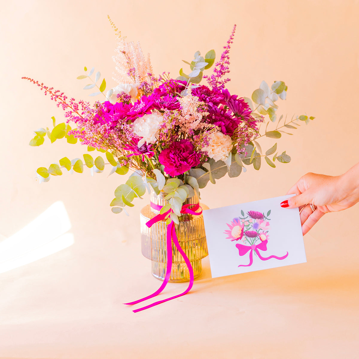 mano sosteniendo la tarjeta floral Proteas junto al ramo en jarrón