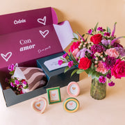 Kit "Para el Recuerdo" de Colvin: ramo de flores rojas en jarrón de cristal junto a caja "Con amor" abierta con cuatro marcos de fotos decorativos en formas de corazón, óvalo, rectángulo y círculo