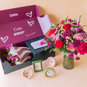 Kit "Para el Recuerdo" de Colvin: ramo de flores rojas en jarrón de cristal junto a caja "Con amor" abierta con cuatro marcos de fotos decorativos en formas de corazón, óvalo, rectángulo y círculo